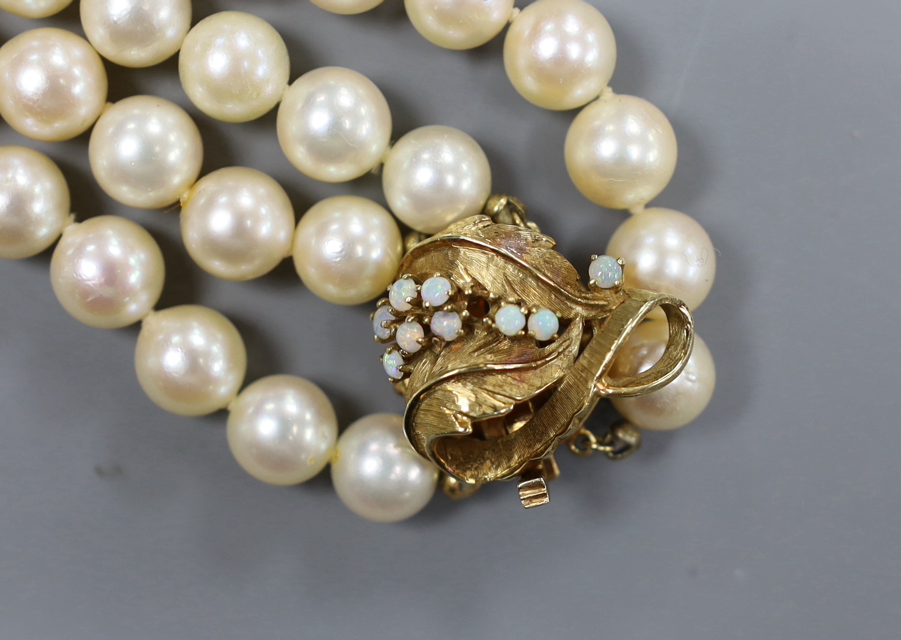 A two strand cultured pearl necklace, with white opal set 14ct gold clasp, 35cm